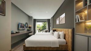 Une chambre d’hôtel moderne avec un grand lit, un bureau doté d’un téléviseur à écran plat et une bibliothèque.