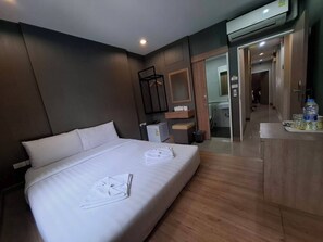 Een moderne hotelkamer met een groot bed, een bureau en een badkamer die door een open deur zichtbaar is.