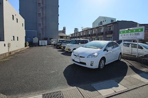 A parking lot with several cars, including a white Toyota, and a building with a sign for Hotel LC Gifu-Hashima. - Hotel LC Gifu-Hashima (Hashima)