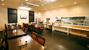 A restaurant with multiple tables and chairs, a kitchen area, and a television mounted on the wall. - Hotel LC Gifu-Hashima (Hashima)