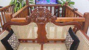 Une chaise en bois avec un dossier en osier et des motifs sculptés décoratifs.
