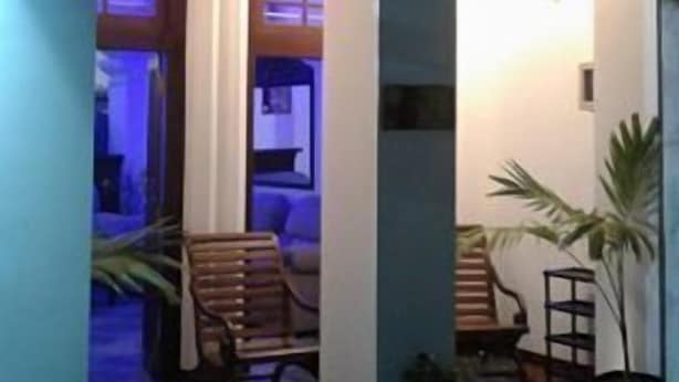 Un espace extérieur abrité, doté d’arcades, de sièges et de plantes en pot.