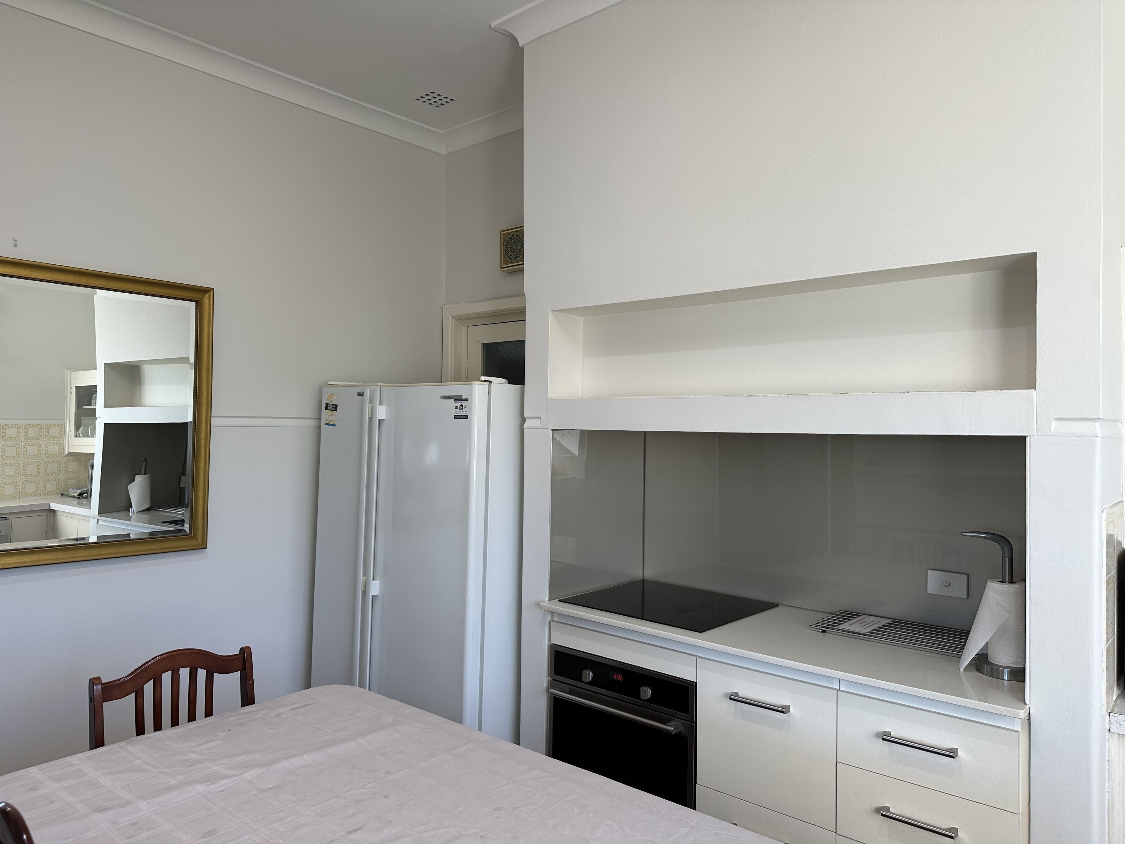 A compact kitchen with a refrigerator, oven, and a small countertop.