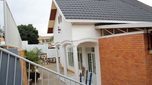 A residential building with a sloped roof, a brick section, and a white exterior. - Mama Rwanda Youth Hostel (Kigali)
