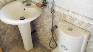 A bathroom with a pedestal sink, a toilet, and a shower. - Eliyana Guest House (Thalaramba)