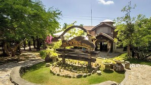 A stone pathway leading to a building with a sign reading "Oldwoods."
