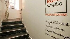 A staircase leading to a room with a sign reading "ROME visits EXCLUSIVE SUITES IN ROME". - Rome Visits (Rome)