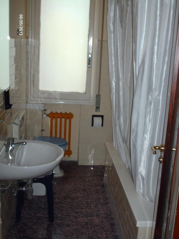 A bathroom with a sink, toilet, and shower curtain.