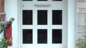 A white door with multiple glass panels and a small overhang above the door. - Albergo Triana e Tyche (Sasso Marconi)