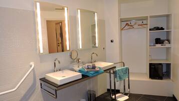 A modern bathroom with two sinks, a mirror, and a shower area.