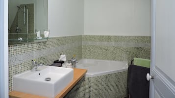 Un baño con lavamanos, bañera y ducha.