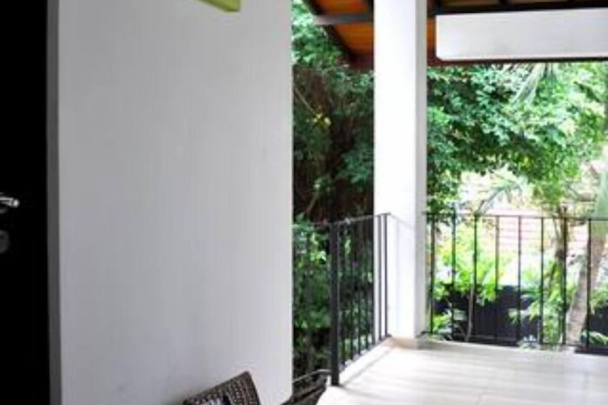 Una habitación amplia con techo de madera, un banco y vistas al exterior con vegetación.