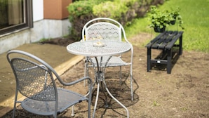 A patio with a round metal table and two metal chairs. - Yamanakako Ryokan RYOZAN (Yamanakako)