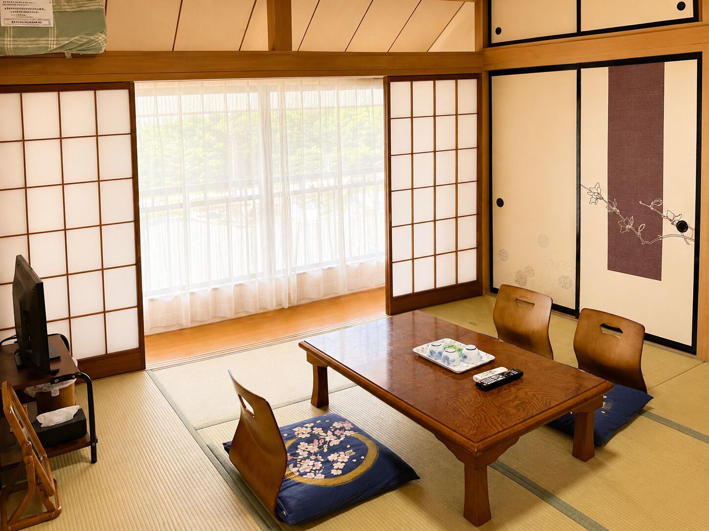 A traditional Japanese room with tatami flooring, a low wooden table, and shoji screens.