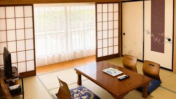 A traditional Japanese room with tatami flooring, a low wooden table, and shoji screens.