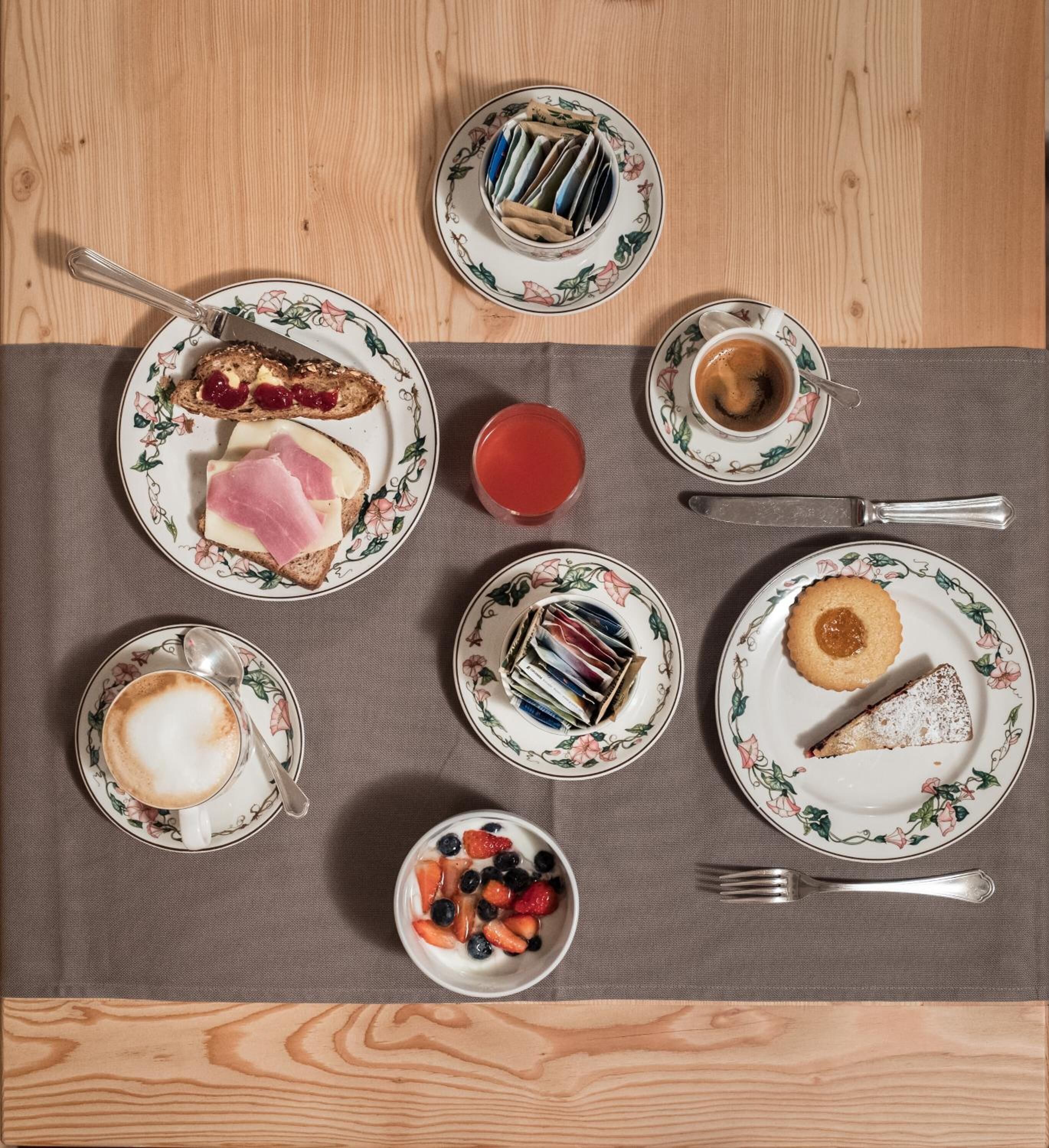 A breakfast setting with various food items and drinks on a table.