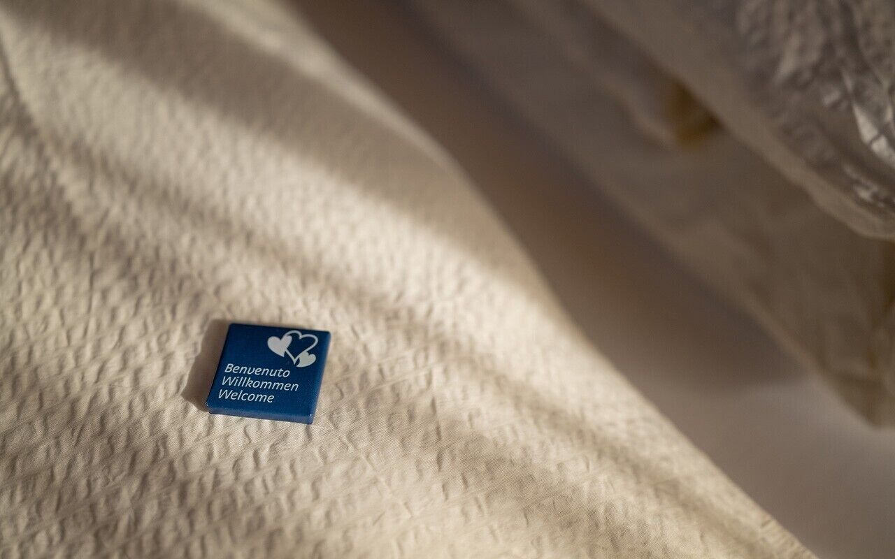 Ein Bett mit einem Schild, auf dem 'Benvenuto Welcome' steht.