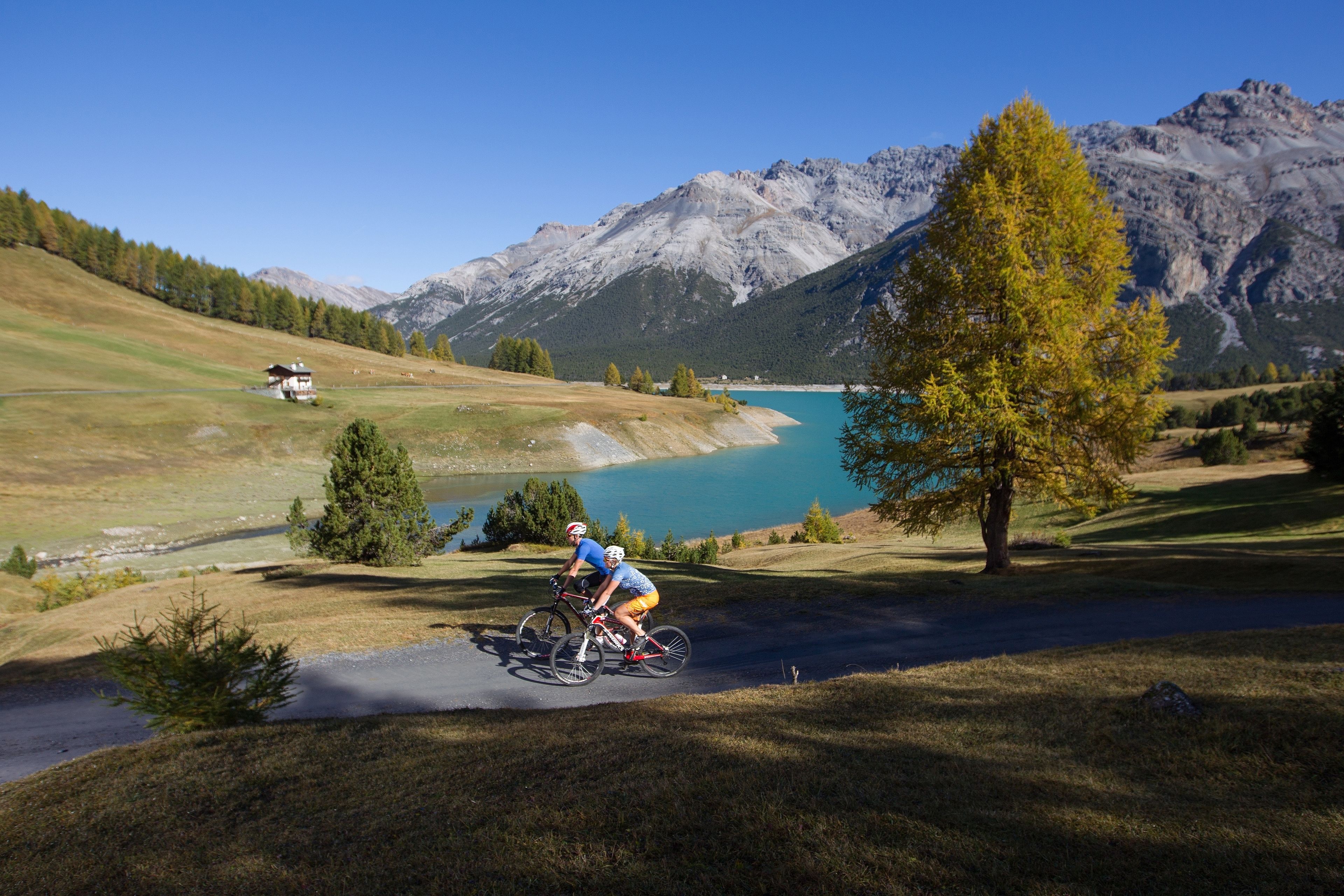 A mountain biking trail with a lake and mountains in the background.