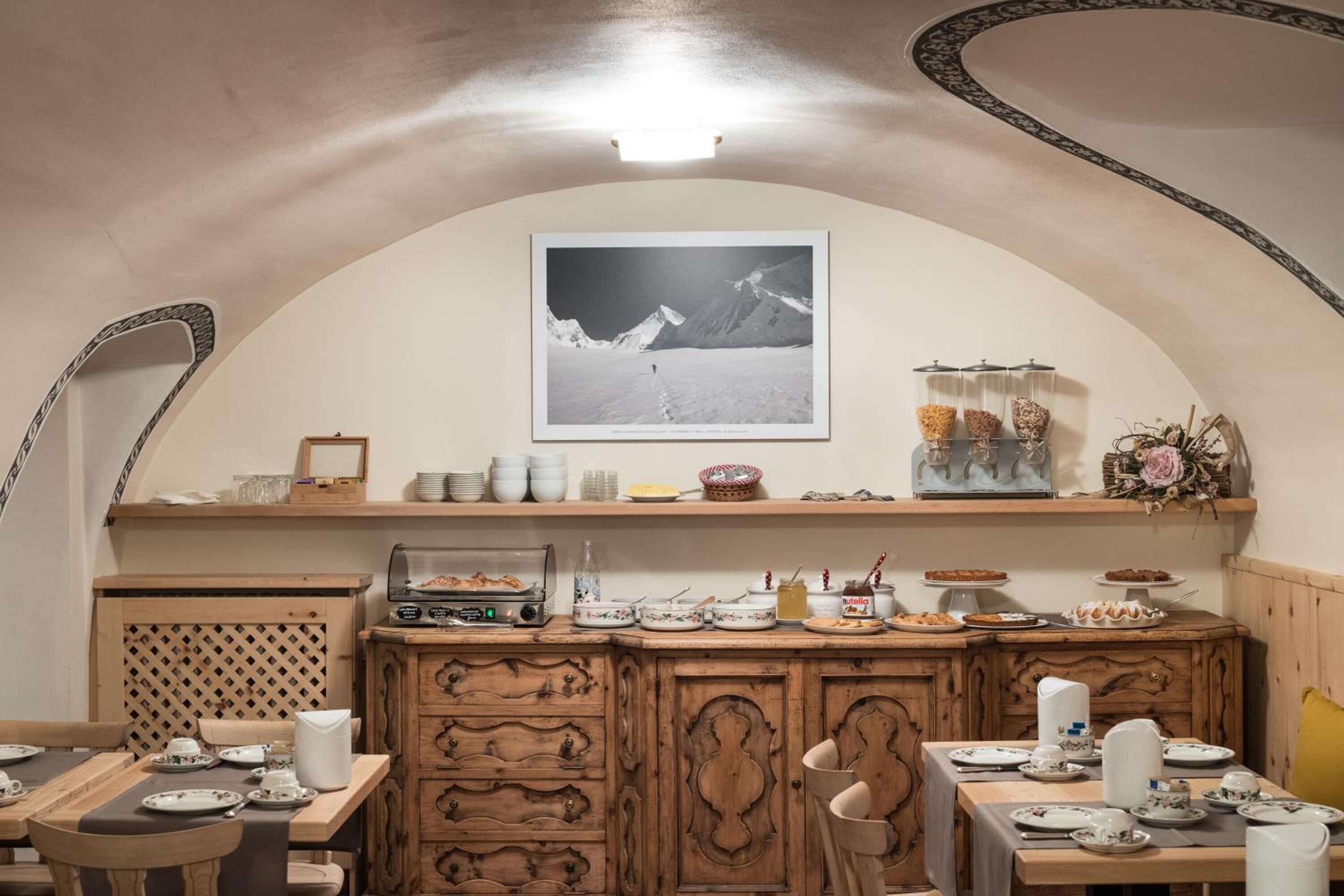Un comedor con un aparador de madera, una fotografía enmarcada en la pared y una lámpara en el techo.