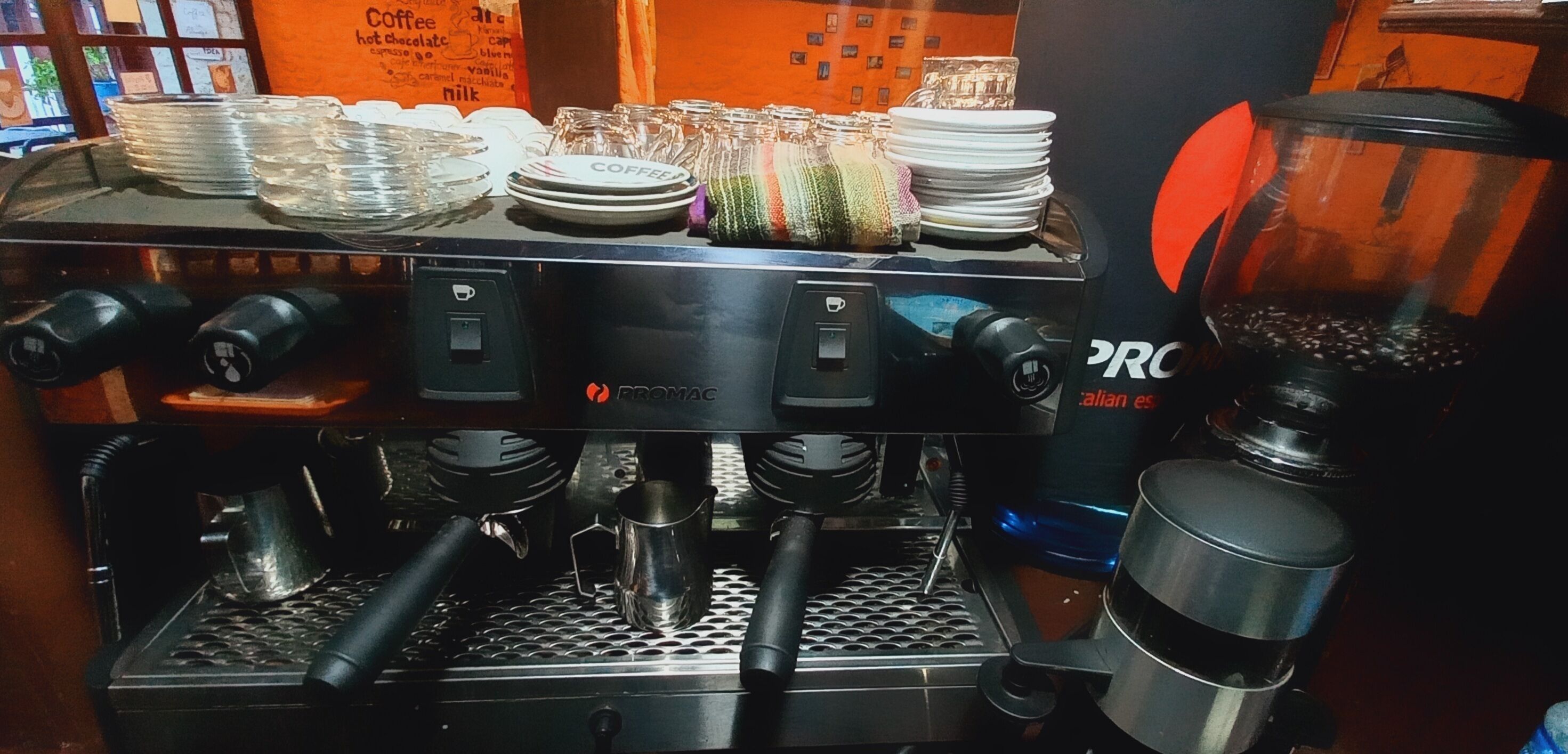 A coffee machine with multiple portafilters and a grinder, indicating a coffee service area.