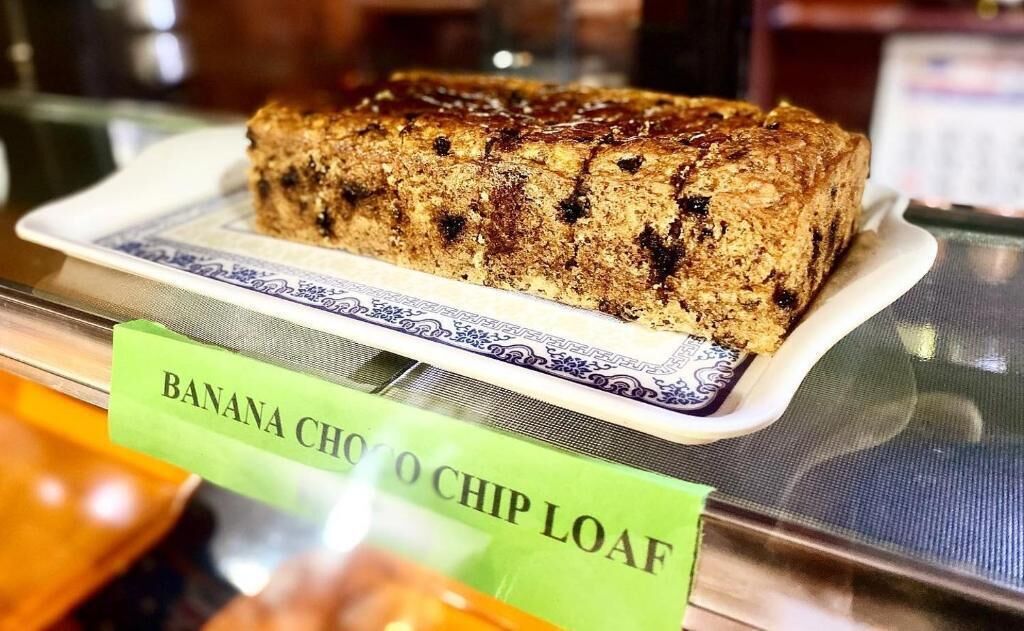 Un pan de plátano y chispas de chocolate sobre un plato con una etiqueta.