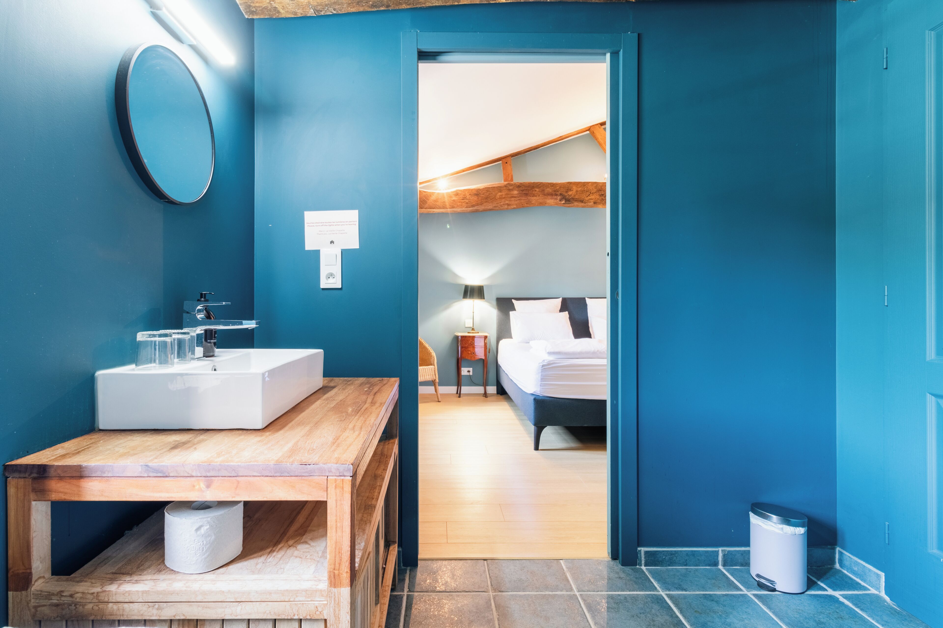 Un baño con tocador de madera, lavabo y espejo.