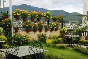 A rooftop garden with potted plants and a table with chairs. - Kathmandu Peace Guest House (Kathmandu)