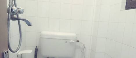 Un baño pequeño y funcional con inodoro blanco, ducha y bañera.