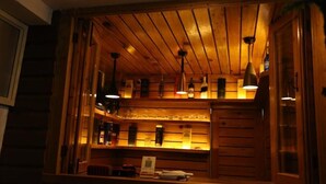 A bar area with wooden paneling and hanging pendant lights. - Sudha's Garden Home (Kathmandu)