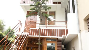 A two-story building with a wooden staircase leading to a balcony. - Sudha's Garden Home (Kathmandu)