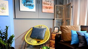 Una sala de estar acogedora con un sillón amarillo, un sofá marrón y decoración inspiradora en la pared.
