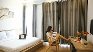 A modern hotel room with a bed, a desk, and a laptop. - Red Hotel Da Nang (Da Nang)