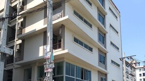 A multi-story residential building with balconies, a gated entrance, and a street sign indicating the address. - J 168 Living (Bangkok)