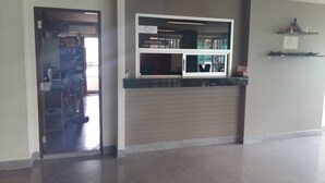 A reception area with a closed door, a counter, and a sign indicating office hours. - J 168 Living (Bangkok)
