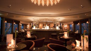A restaurant with round tables, chairs, and a bar area. - Crossgates Hotelship Messe - Köln (Cologne)