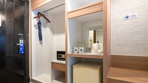 A compact hotel room with a wooden wardrobe, a small kitchenette, and a mirror. - Kokotel Phuket Patong (Patong)