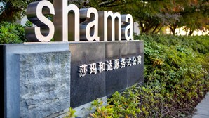 Une enseigne portant le mot « Shama » et des caractères chinois, le tout entouré de verdure.