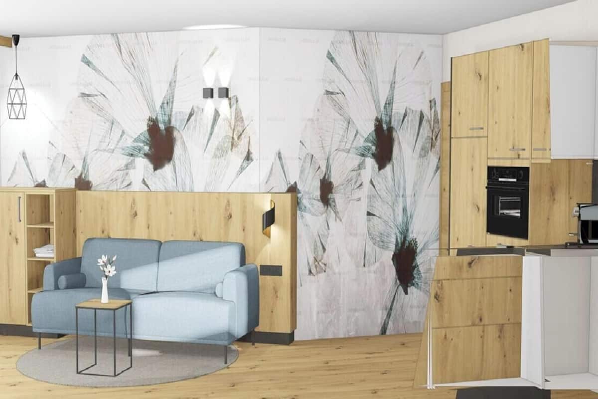 Una sala moderna con un sofá, una mesita con un florero, un mueble de madera y una cocina con estufa.