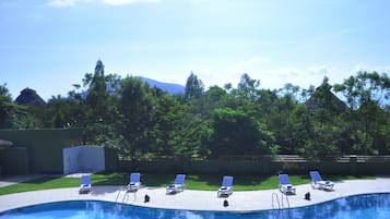 Een buitenzwembad, parasols voor strand/zwembad