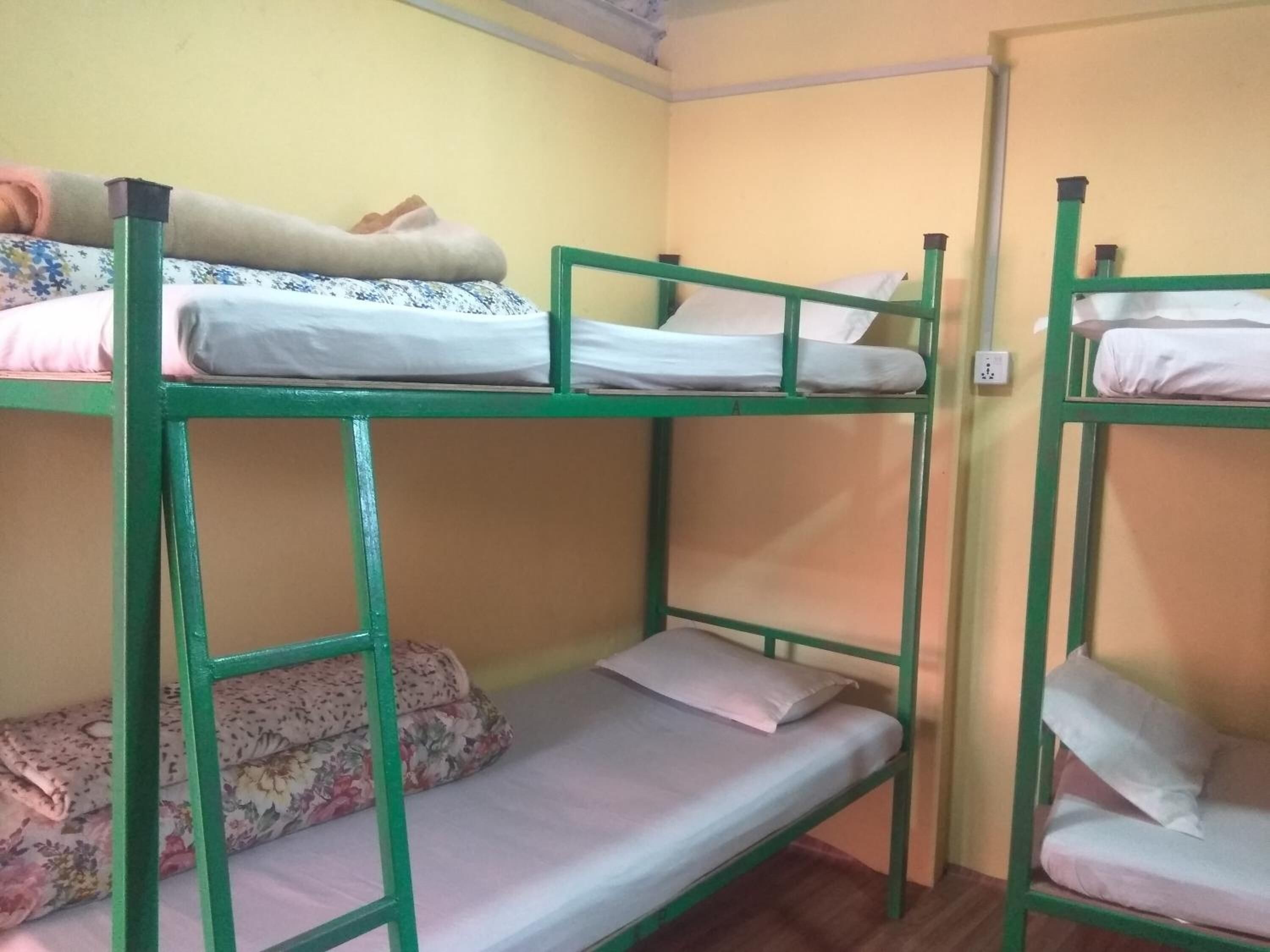 Ein Schlafraum mit Etagenbetten, jeweils ausgestattet mit Kopfkissen und Decke.