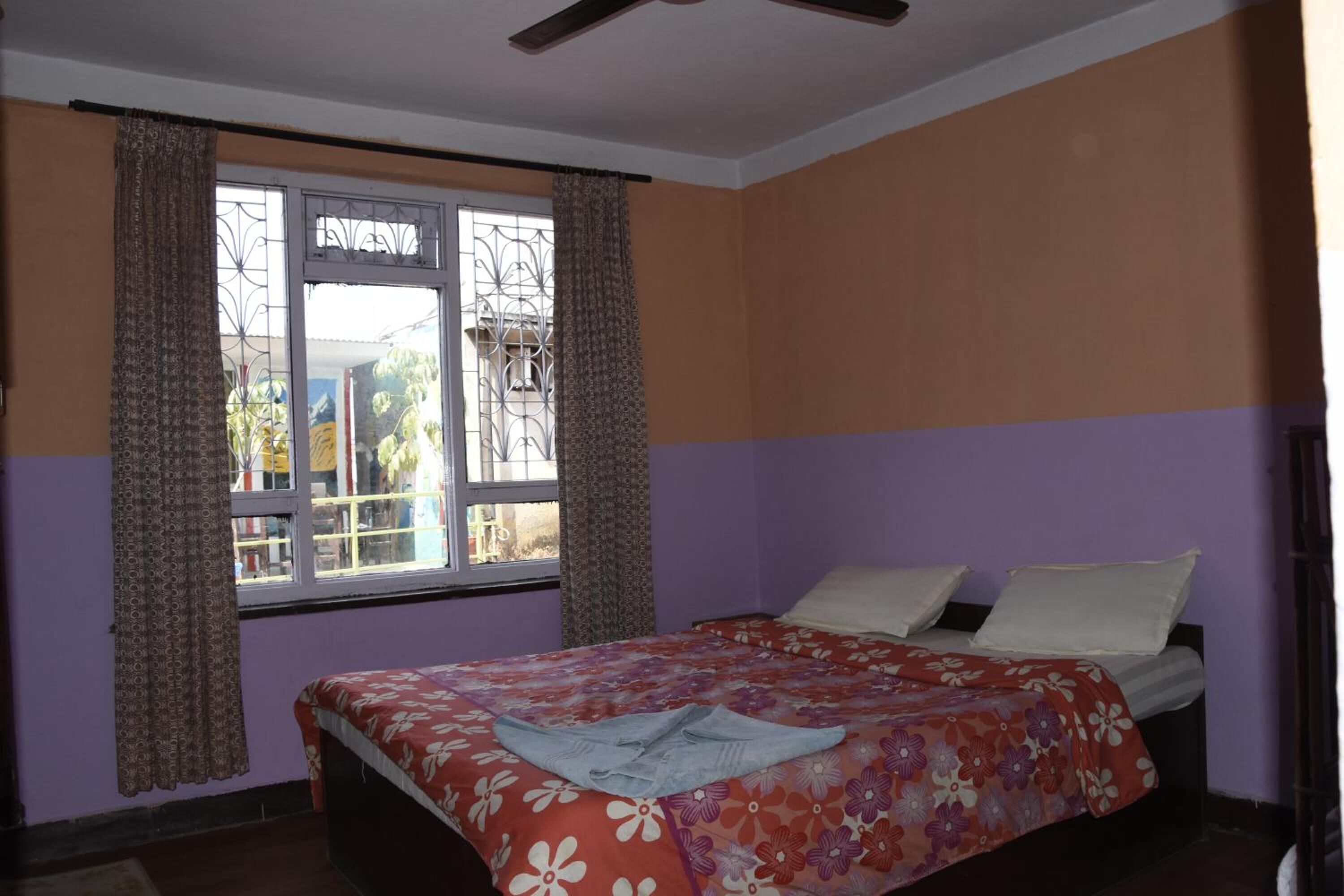 A bedroom with a bed, curtains, and a window.