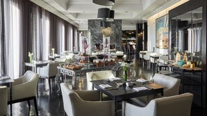 A spacious dining area with high ceilings, elegant chandeliers, and a central bar.