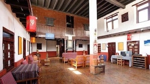 A traditional inn with wooden floors, multiple seating areas, and a balcony. - Hotel Om's Home (Jomsom)