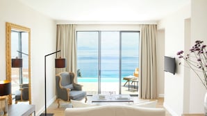 Una sala de estar moderna con un ventanal grande que da a una piscina y al mar.