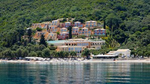 A coastal hotel with multiple buildings, a beach, and a forested hillside. - Nido, Mar-Bella Collection (Corfu)