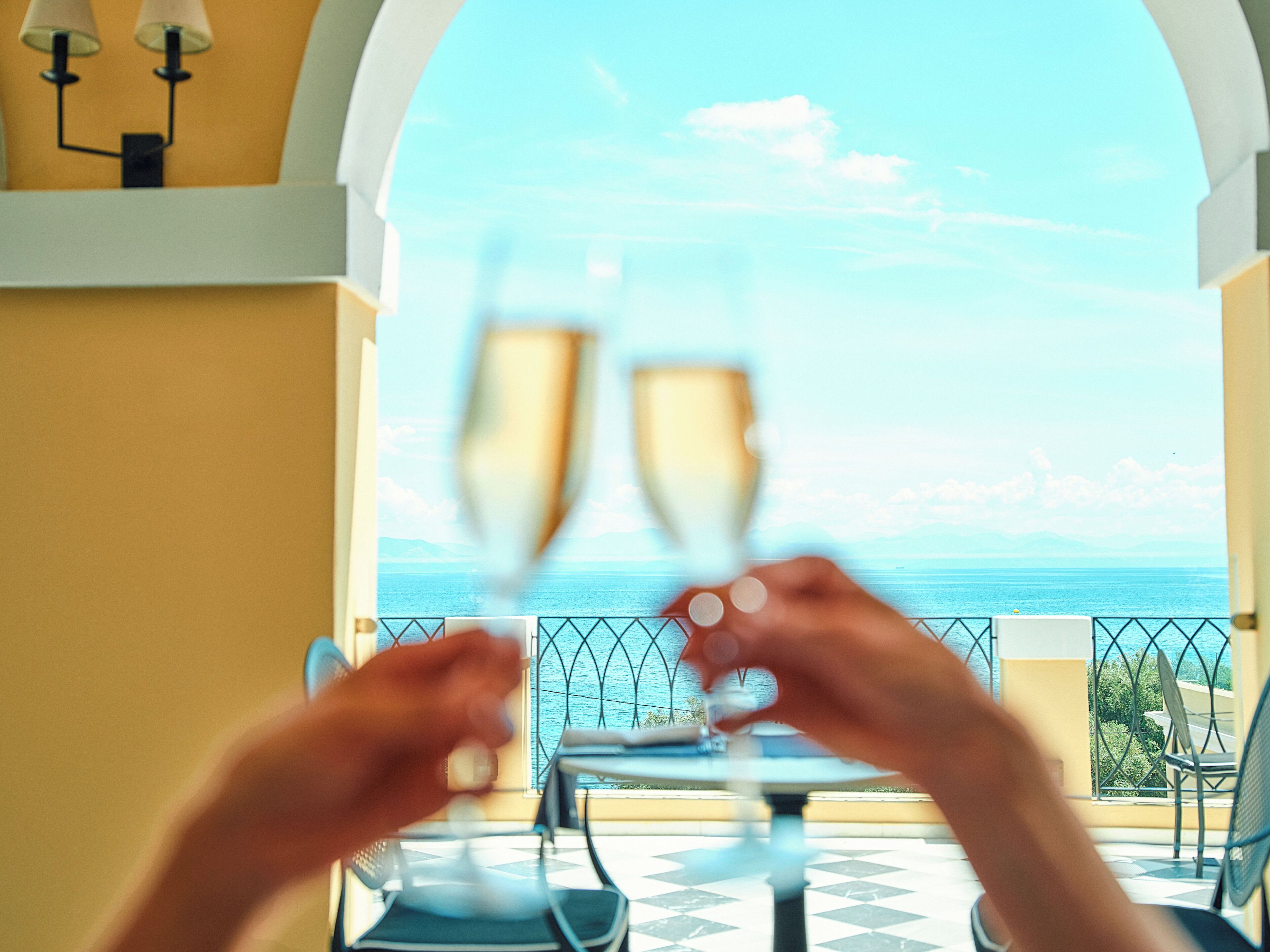 A balcony with a table and chairs, overlooking a body of water.