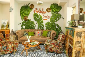 A cozy living room with a brown sofa, green cushions, and a coffee table with magazines. - Dalyan Basar Hotel (Ortaca)