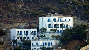 Un edificio blanco con balcones azules y un letrero que dice 'HOTEL GLAUS'.