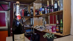 Una stanza con un minibar fornito di diverse bevande alcoliche, tra cui bottiglie di Moët & Chandon e altre marche.