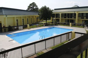 Una piscina al aire libre de temporada, sombrillas